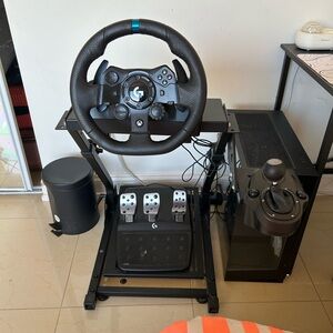 Logitech Racing Wheel with Pedals, 2 Xbox ones, 1 Xbox series x, and 2 Nintendos